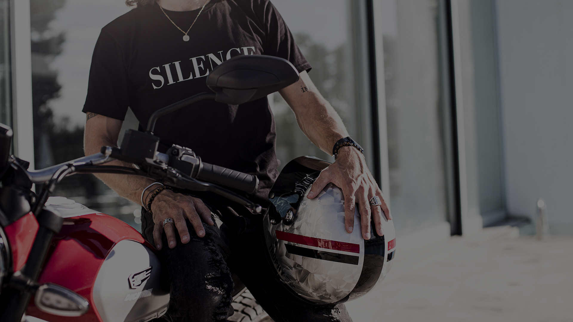 Motociclista con il casco in mano